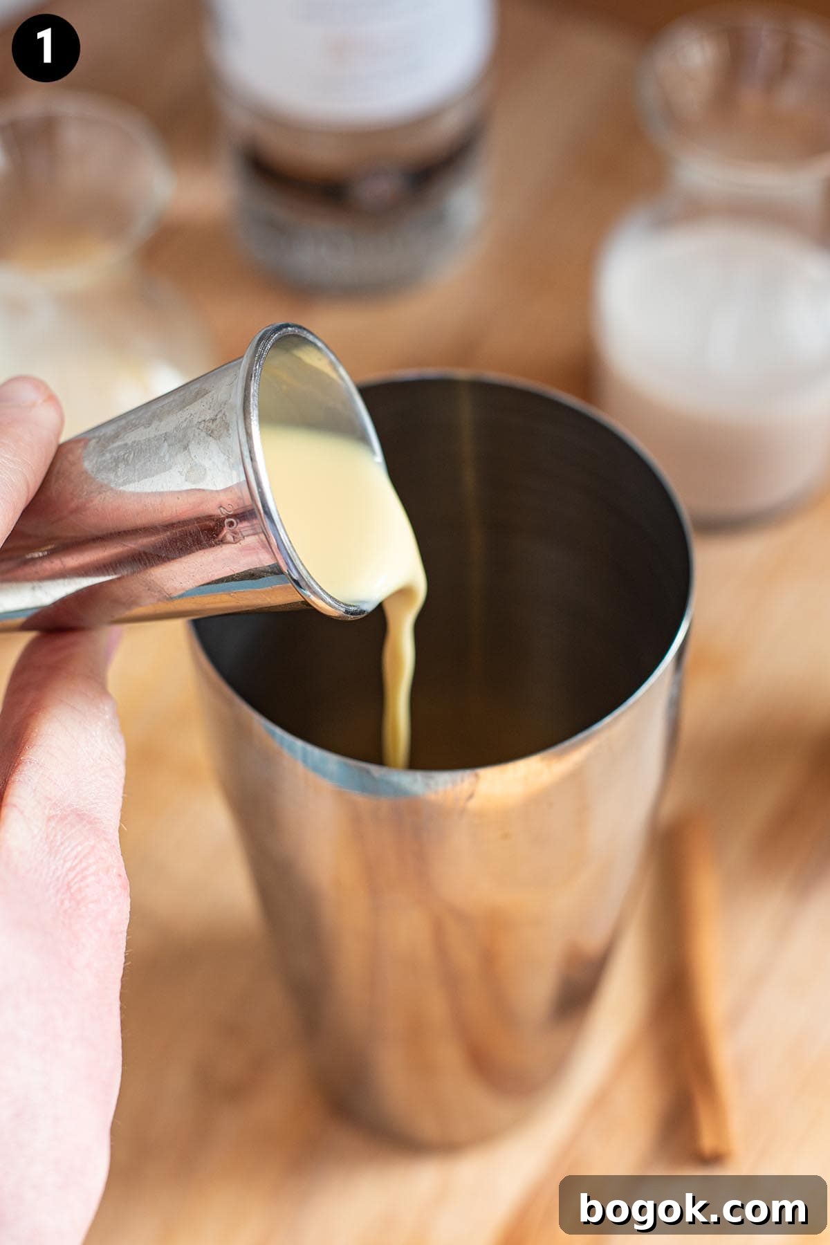 Creamy Eggnog Cocktail Recipe for Holiday Parties 4 Pouring eggnog into a cocktail shaker with a cocktail jigger.