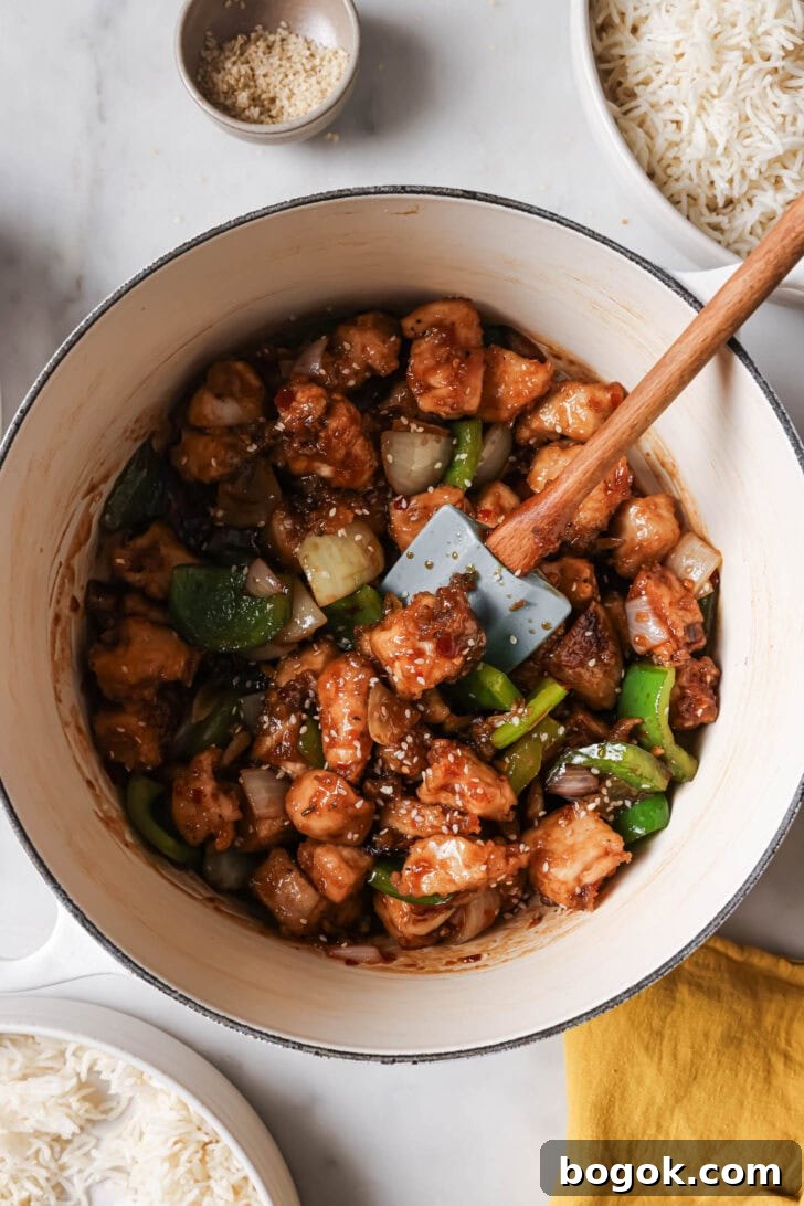 Top view of Honey Ginger Chicken in a pot surrounded by bowls of rice.
