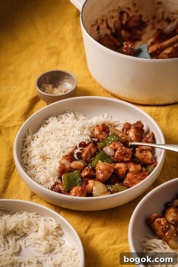 A plate of Honey Ginger Chicken on the table along with the serving pot in the background.