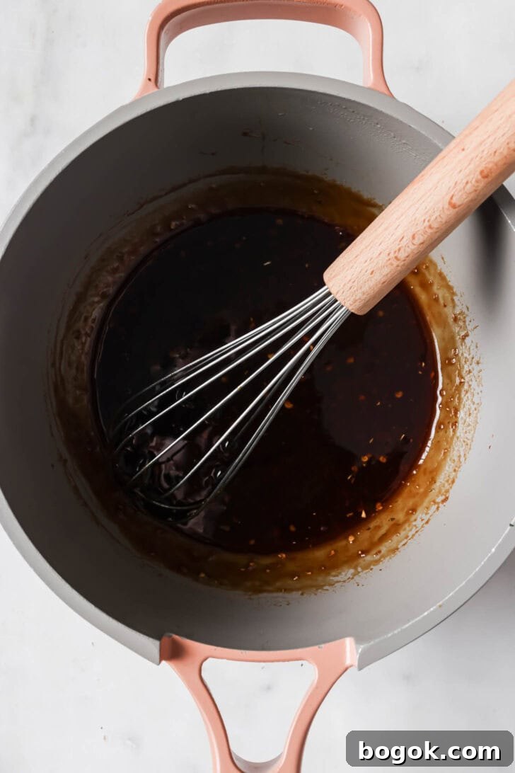 Cooking sauce in a pot to make Honey Ginger Chicken.