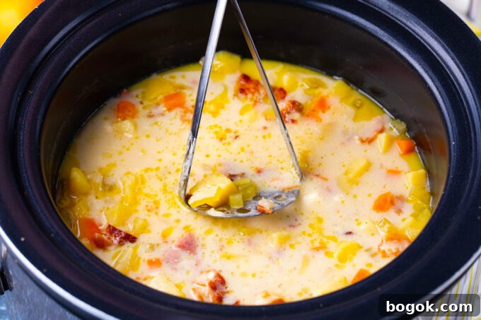 Creamy Slow Cooker Ham & Potato Soup Recipe 8 Mashing slow cooker ham and potato soup.