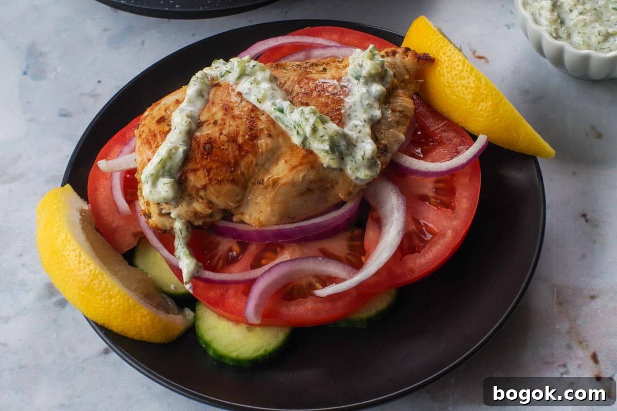 Greek Chicken Souvlaki Without Skewers — Weight Watchers Recipe 13 Tzatziki drizzled over chicken breast on bed of veggies.