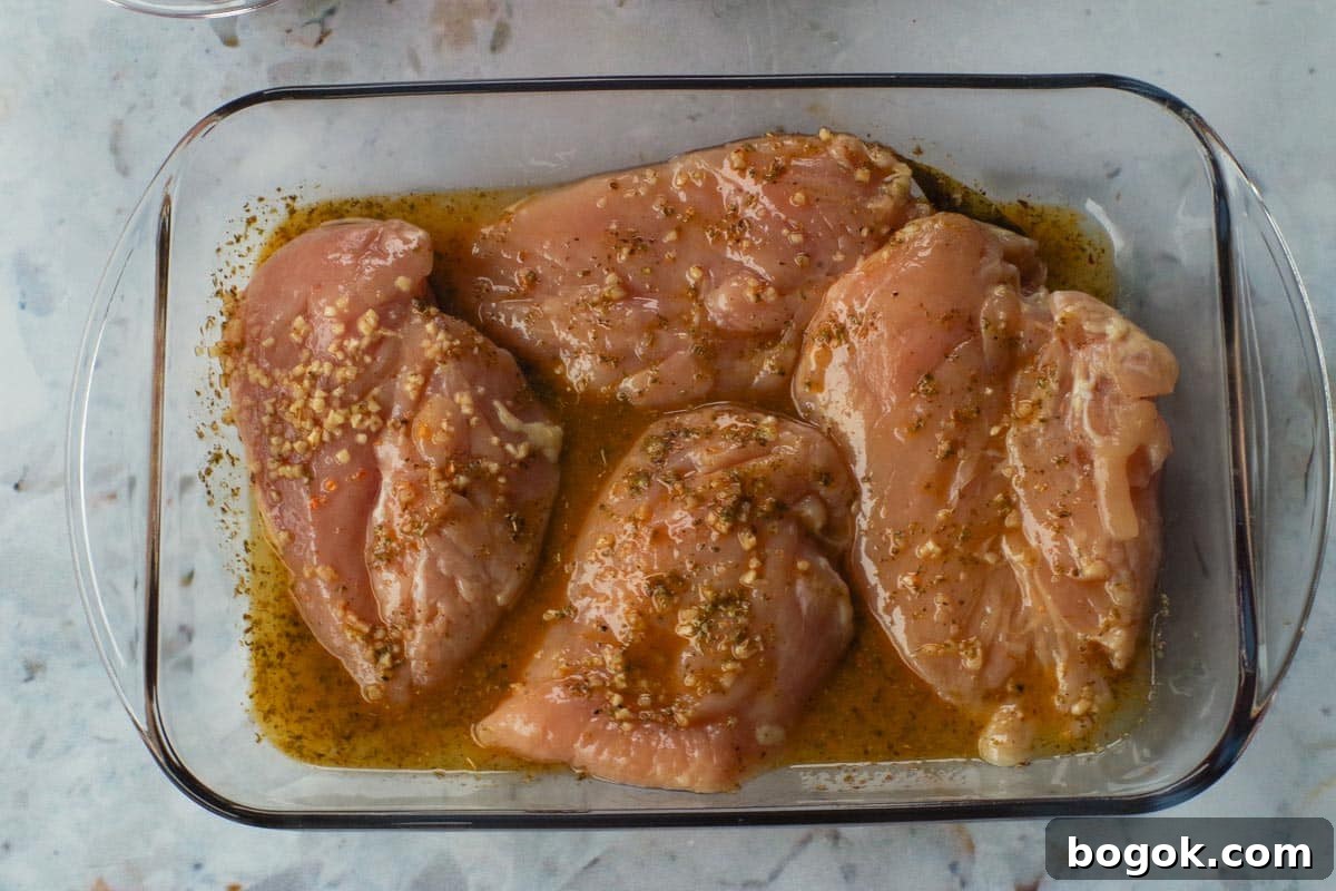 Greek Chicken Souvlaki Without Skewers — Weight Watchers Recipe 7 Marinade poured over chicken in glass container.