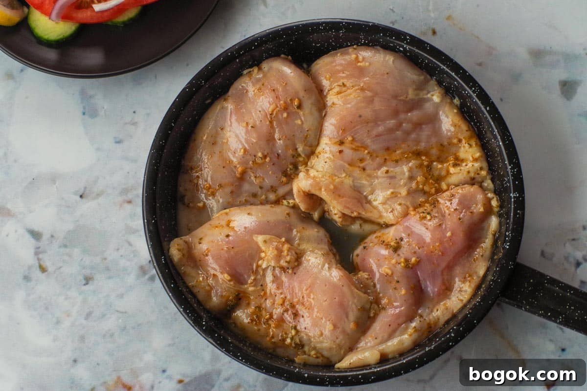Greek Chicken Souvlaki Without Skewers — Weight Watchers Recipe 8 Raw marinated chicken in frying pan.