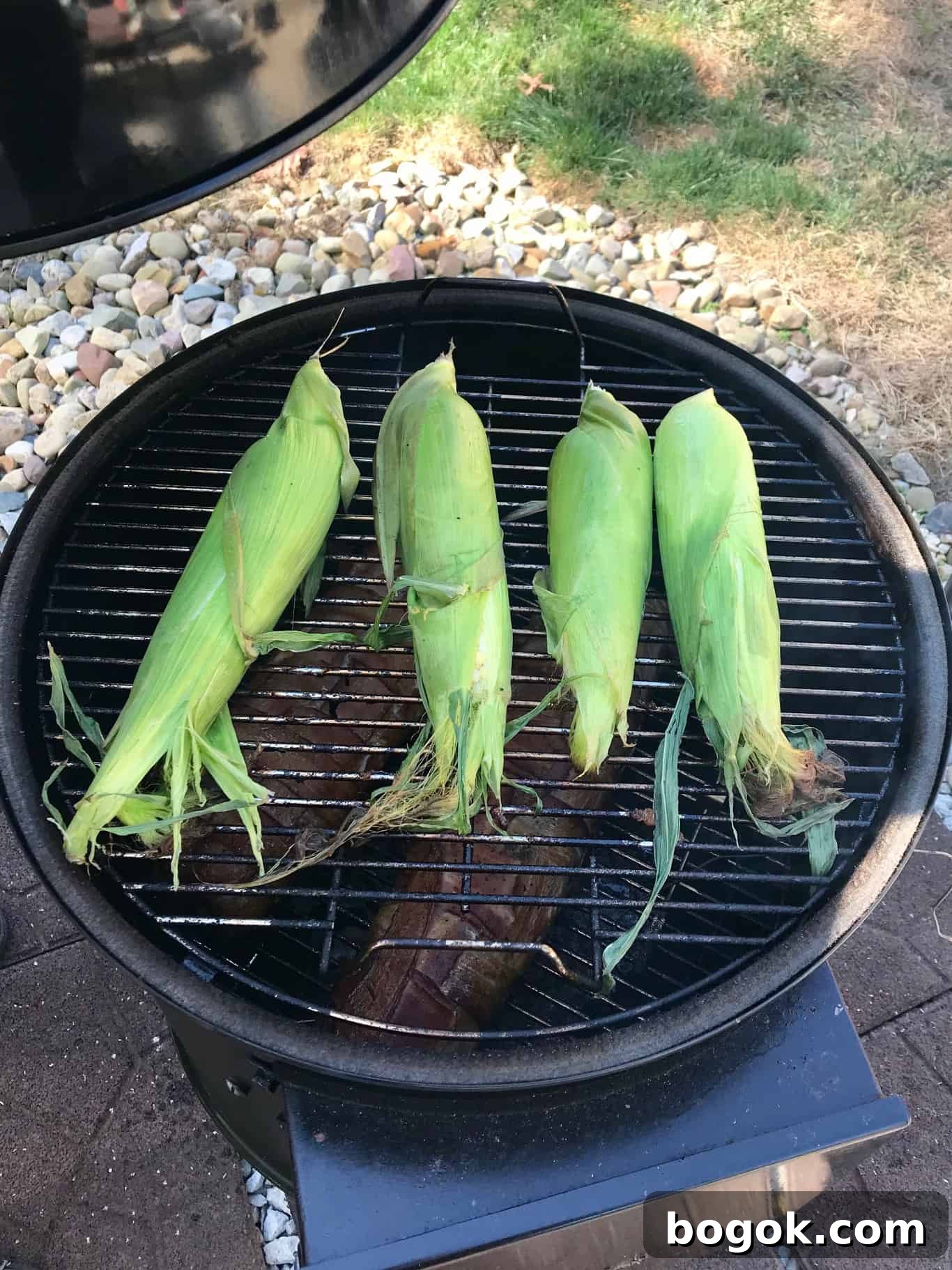 Smoked Corn on the Cob Recipe: Juicy Grilled Sweet Corn with Smoke 2 Corn on the cob still in husks on weber grill