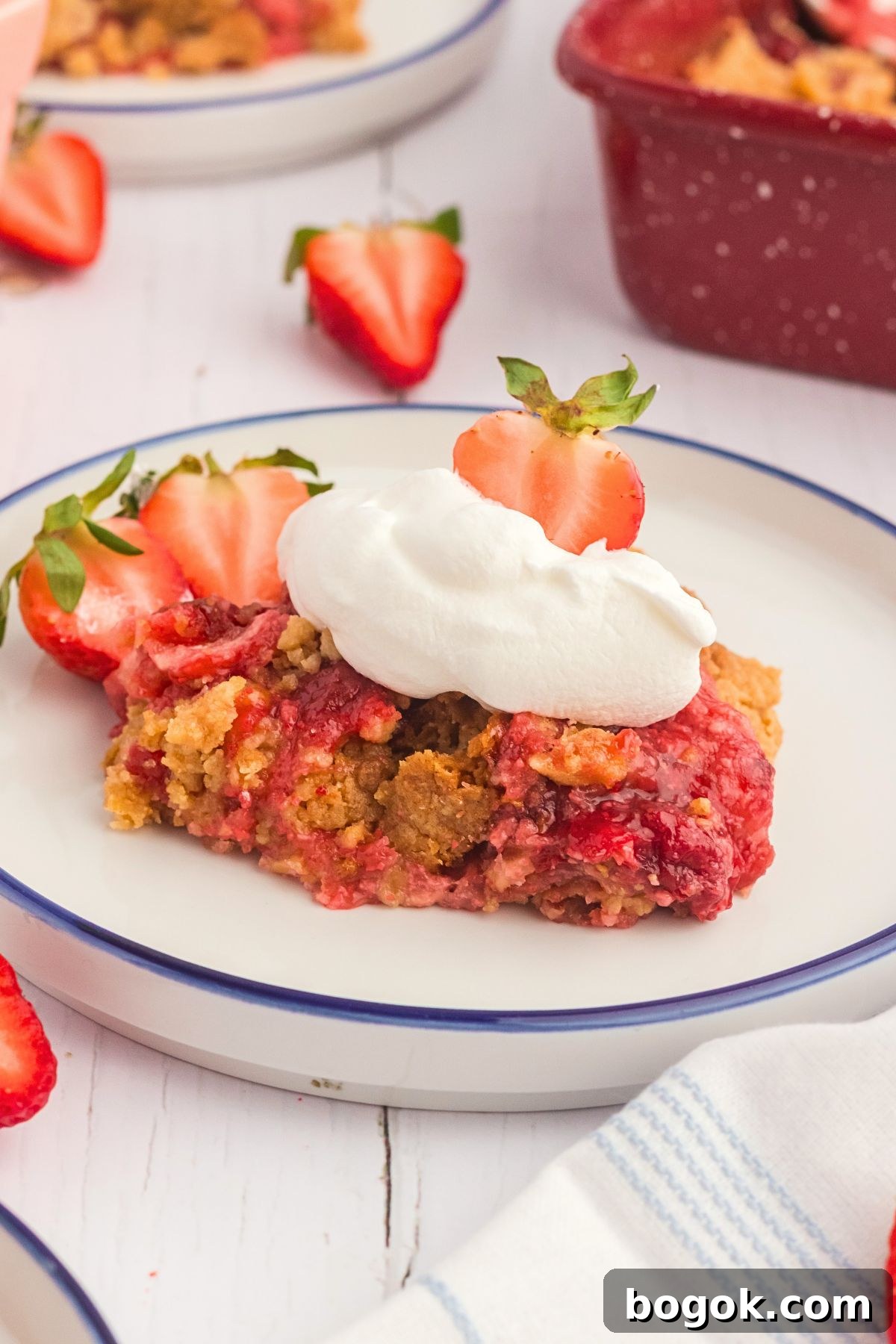 Golden cake crumble on strawberry pie filling on a white plate. 