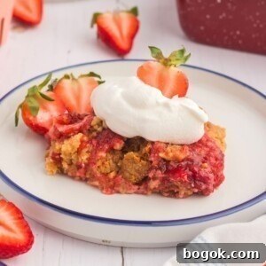 Golden cake crumble on strawberry pie filling on a white plate.