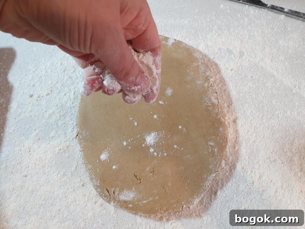 sprinkling more flour on dough to prevent rolling pin sticking.