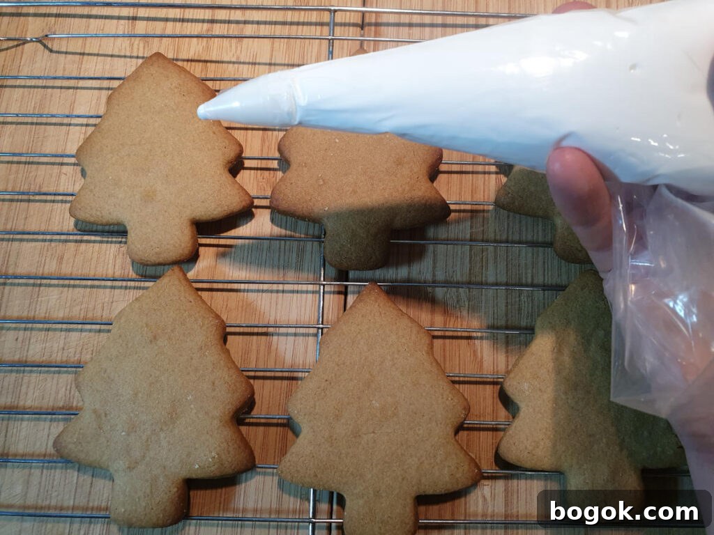 piping icing onto gingerbread trees to decorate.