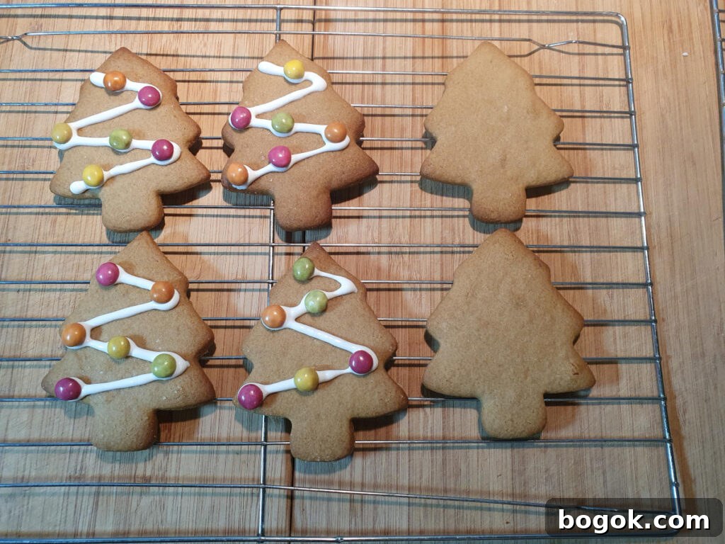 decorated gingerbread Christmas trees on wire rack drying.