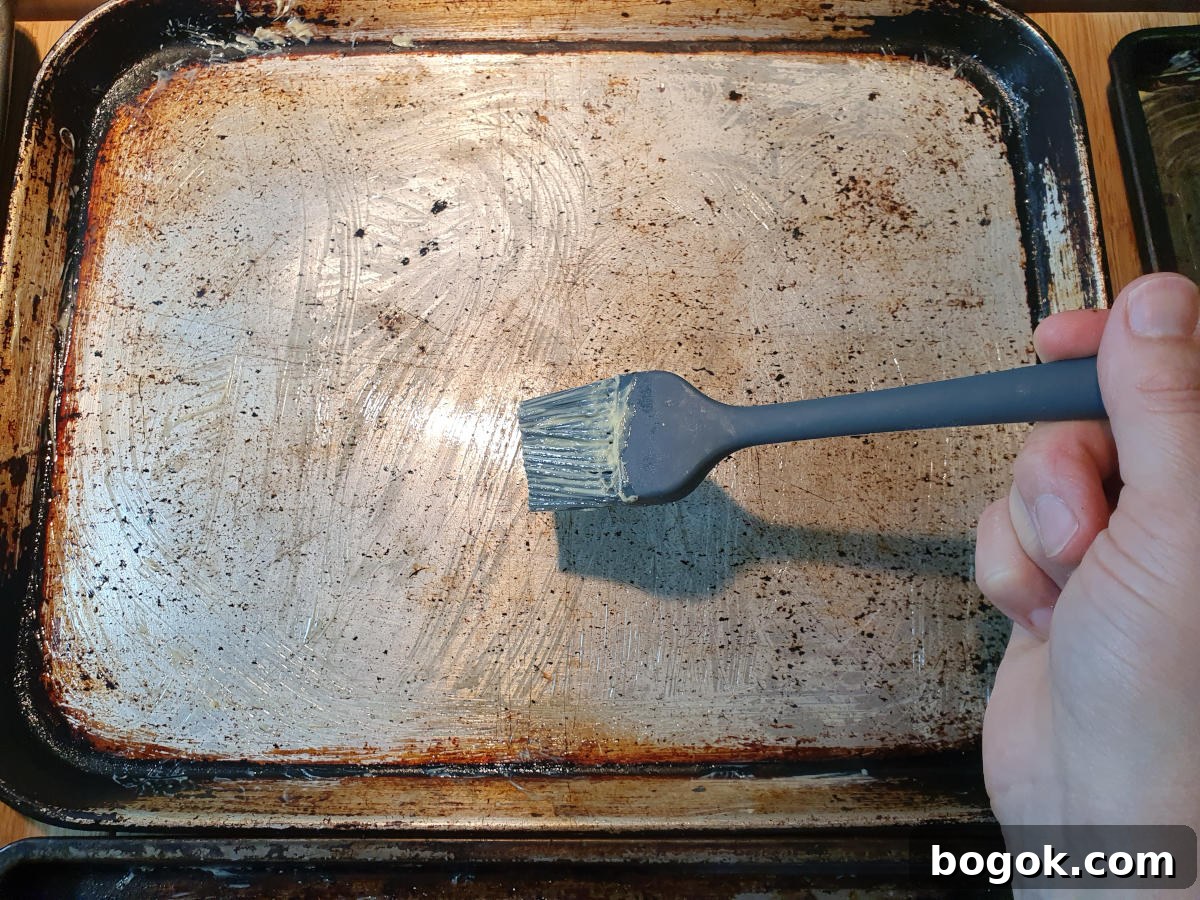 greasing trays with pastry brush and butter.