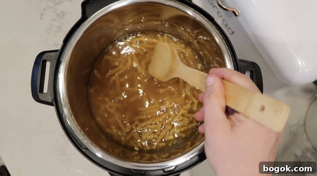 Garlic Herb Cheese Pasta Made in the Instant Pot 6 Submerging pasta in Instant Pot in broth