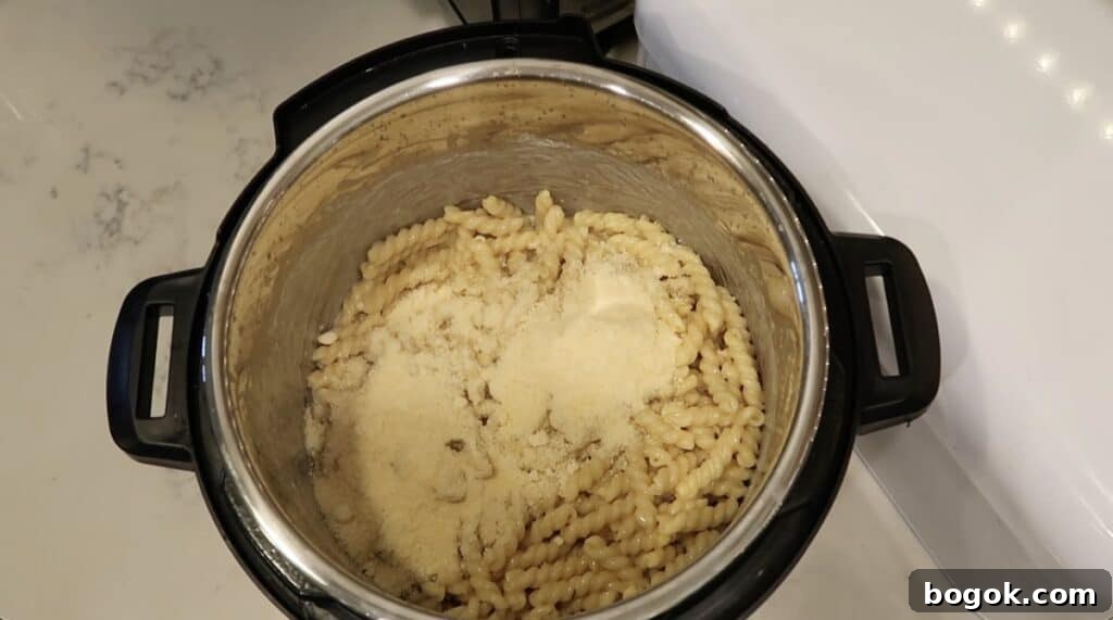 Garlic Herb Cheese Pasta Made in the Instant Pot 9 Adding grated Parmesan to pot