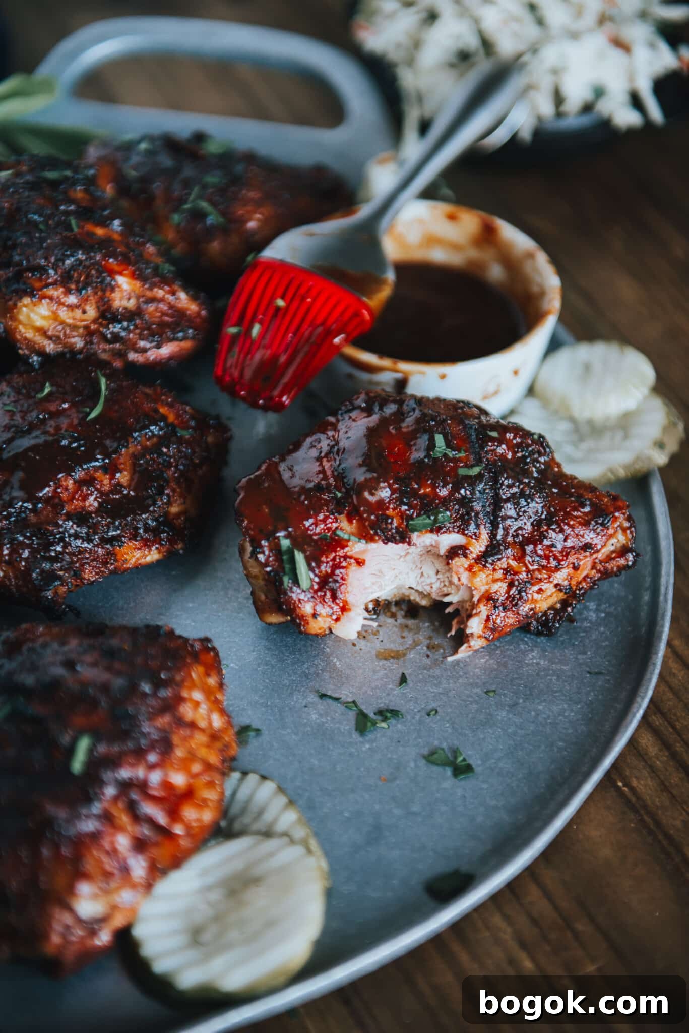 Chicken thigh on platter with bite taken out of it. 