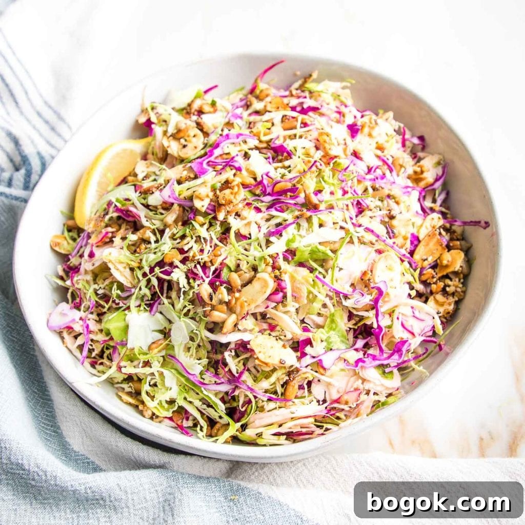 Brussels sprouts slaw prepped before being dressed with purple cabbage and toasted nuts and lemon juice