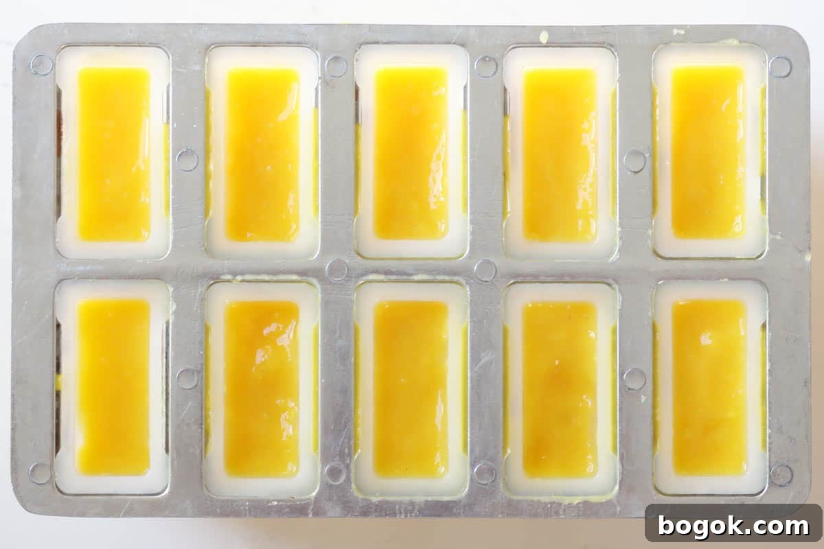 a popsicle mold filled with mango puree