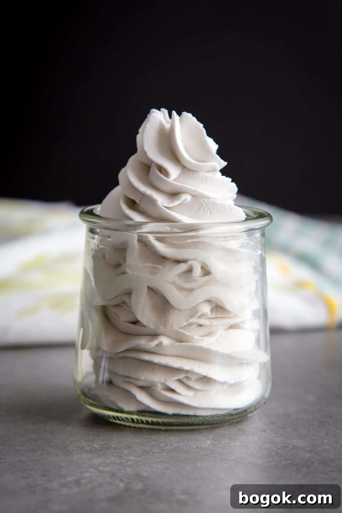 Coconut Whipped Cream swirls in a glass jar.