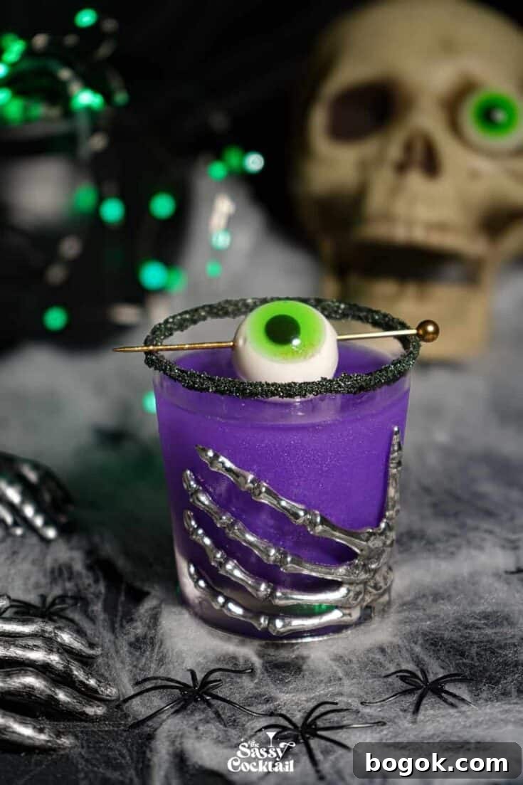 A purple Halloween margarita garnished with an eyeball.