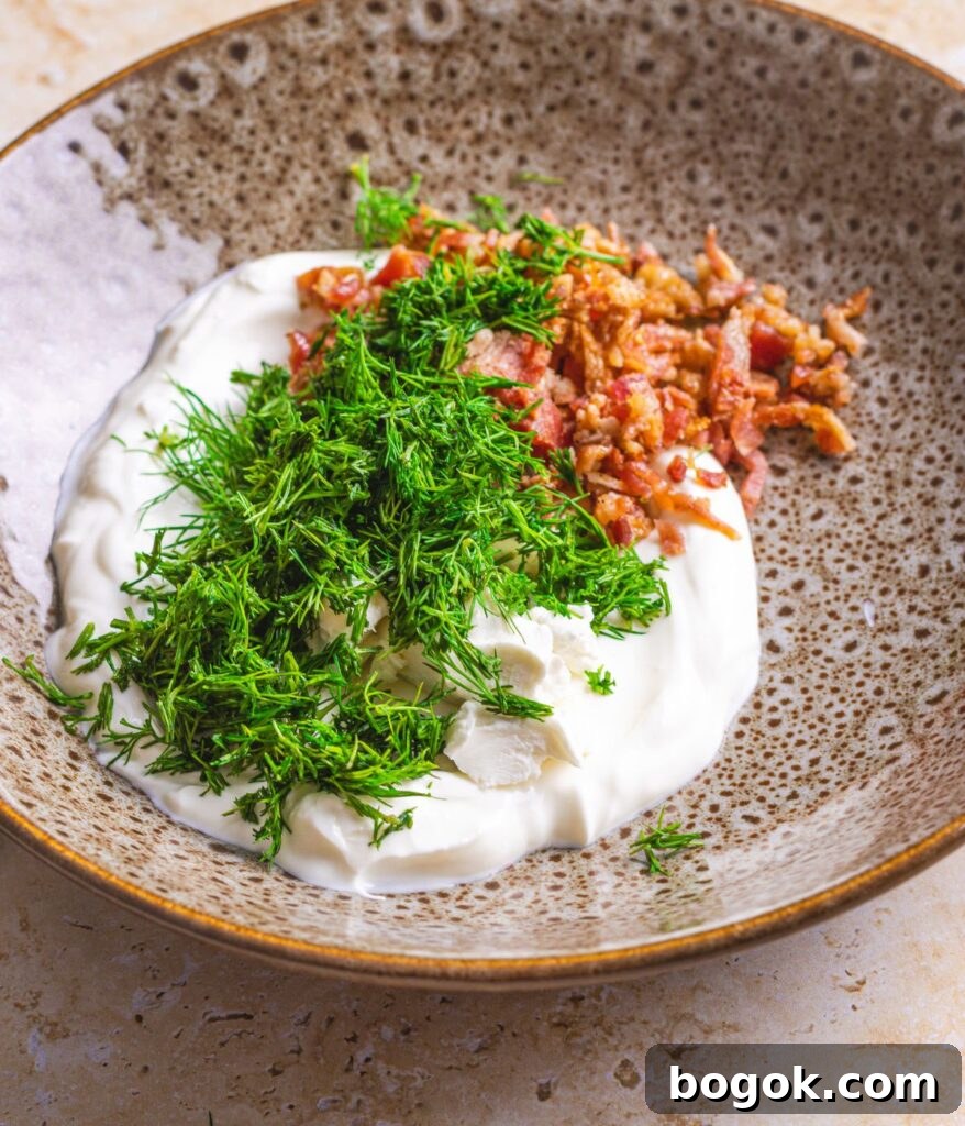 sour cream with dill and bacon getting mixed in a bowl