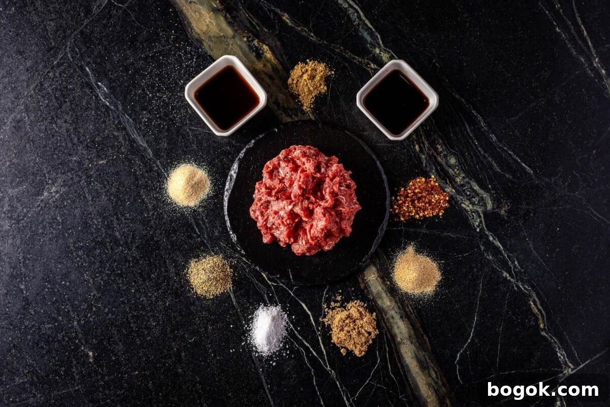 Worcestershire and soy sauces in glass bowls, surrounded by raw seasoning ingredients on a countertop.