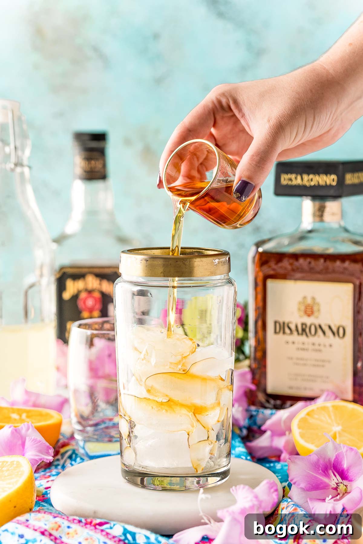 Classic Amaretto Sour Cocktail Recipe with a Citrus Twist 4 Amaretto being added to a cocktail shaker with ice.