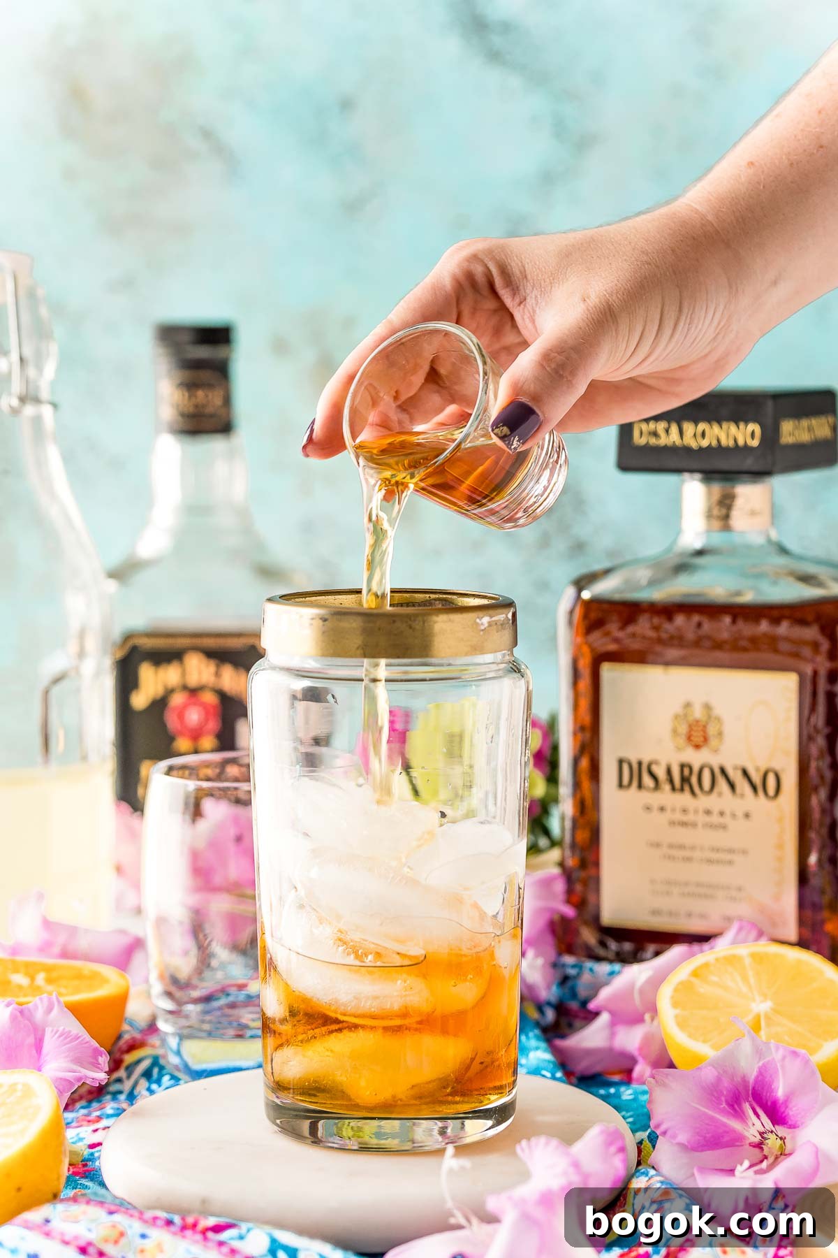 Classic Amaretto Sour Cocktail Recipe with a Citrus Twist 5 Bourbon being added to a cocktail shaker.