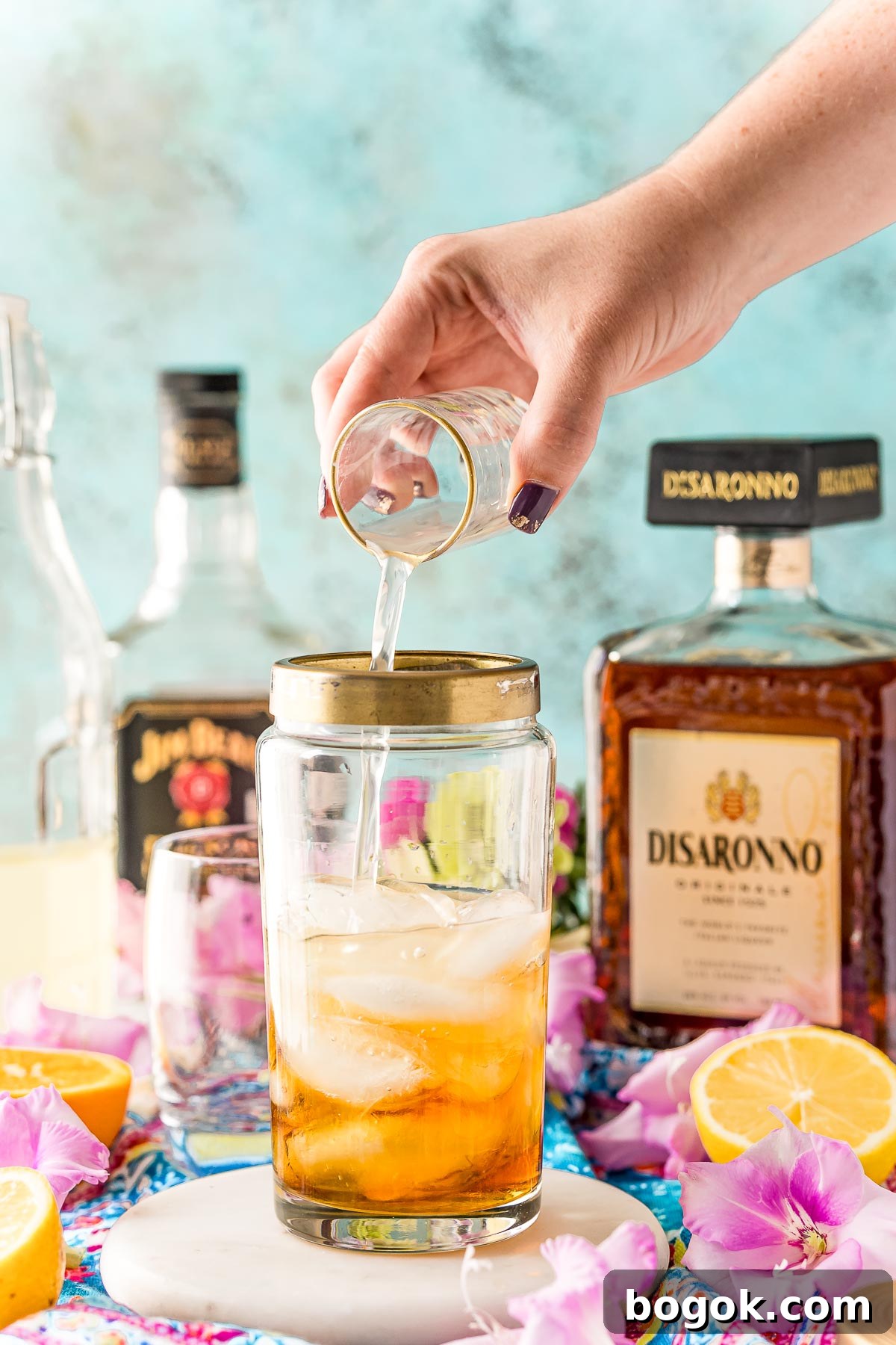 Classic Amaretto Sour Cocktail Recipe with a Citrus Twist 6 Sour mix being added to a cocktail shaker.