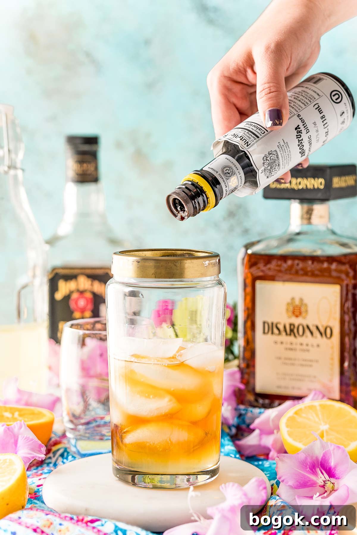 Classic Amaretto Sour Cocktail Recipe with a Citrus Twist 7 Angostura bitters being added to a cocktail shaker.