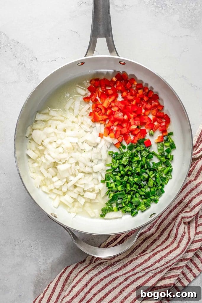 onion, bell pepper, and poblano pepper on a skillet