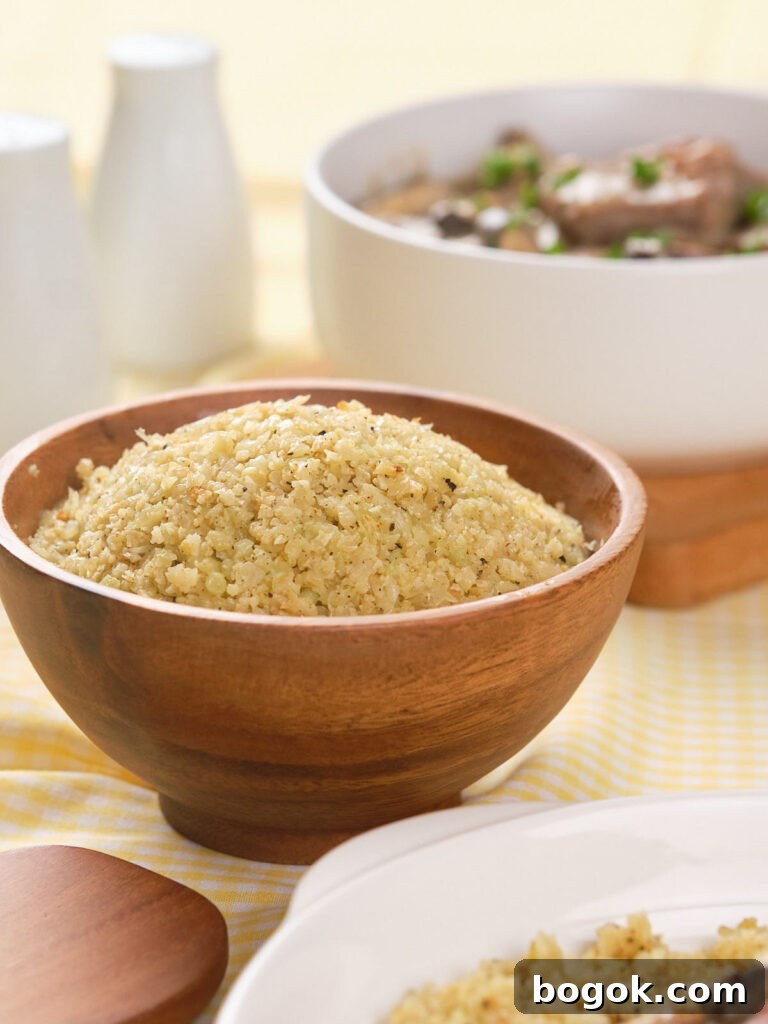 How to Make Cauliflower Rice at Home: Simple Step-by-Step Guide 5 A wooden bowl filled with seasoned couscous sits on a yellow checkered cloth, with a white serving bowl and white containers in the background.