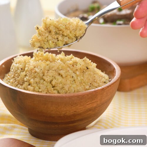 How to Make Cauliflower Rice at Home: Simple Step-by-Step Guide 6 A hand holds a spoonful of cooked cauliflower rice above a wooden bowl filled with more cauliflower rice, with dishes and condiments in the background.