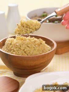 How to Make Cauliflower Rice at Home: Simple Step-by-Step Guide 10 A hand holds a spoonful of cooked cauliflower rice above a wooden bowl filled with more cauliflower rice, with dishes and condiments in the background.