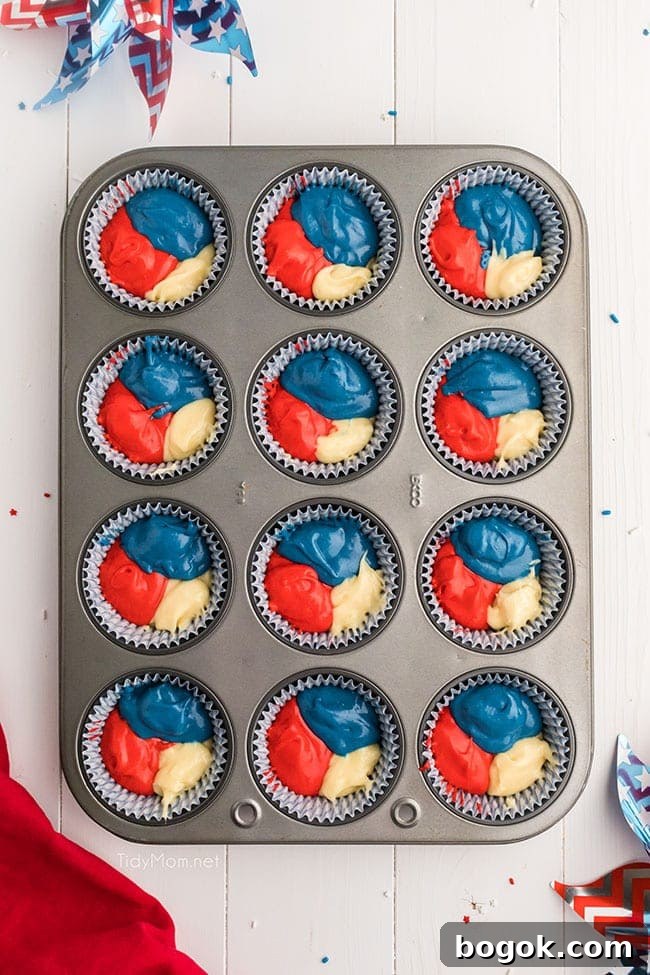 red white and blue cupcake batter in cupcake wells