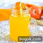 Boozy hot apple cider in glass mug garnished with apple slice and cinnamon stick