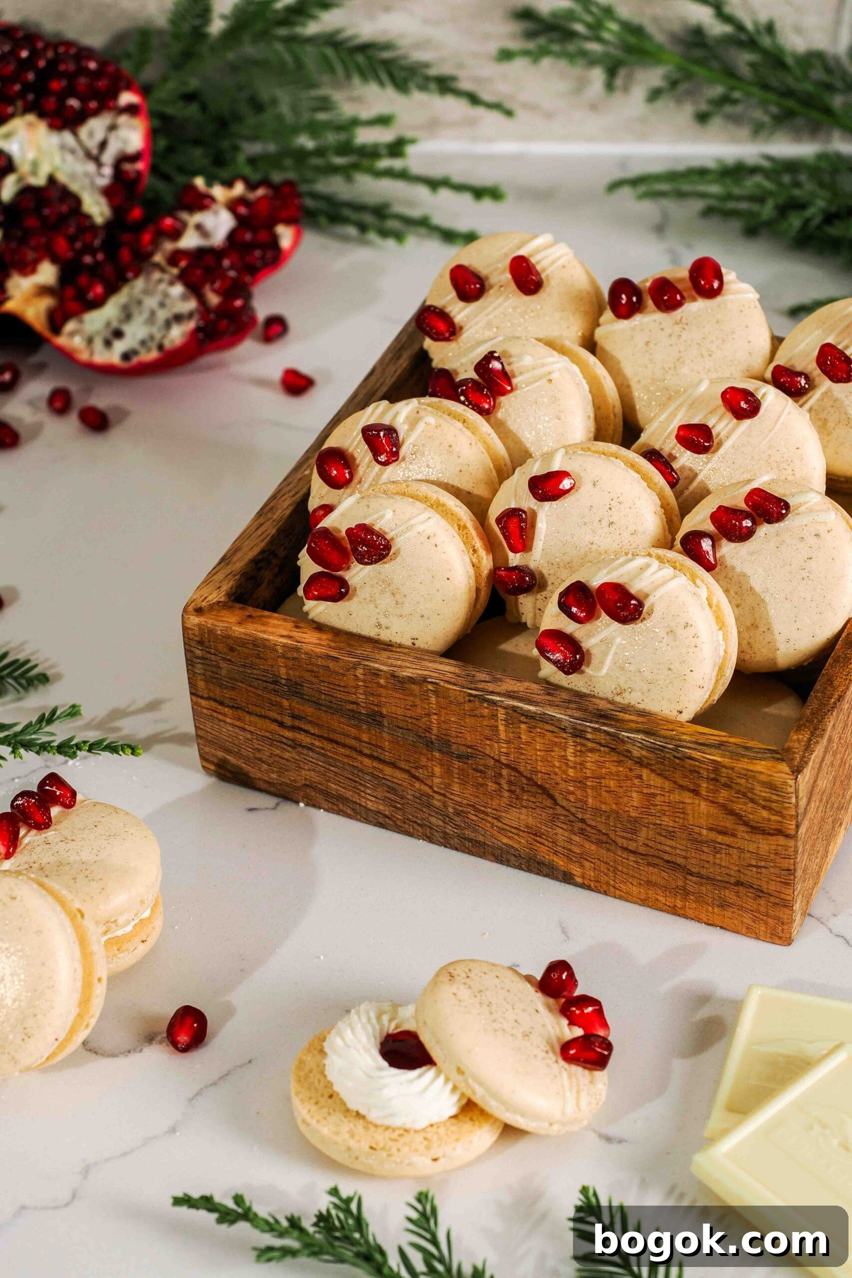 White Chocolate and Pomegranate Macarons — Recipe & Tips 2 A wooden box full of white chocolate pomegranate macarons.