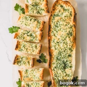 Garlic Bread Recipe with Crispy Herb Butter Crust 8 Two loaves of garlic bread topped with an herbed butter spread with one sliced into pieces.