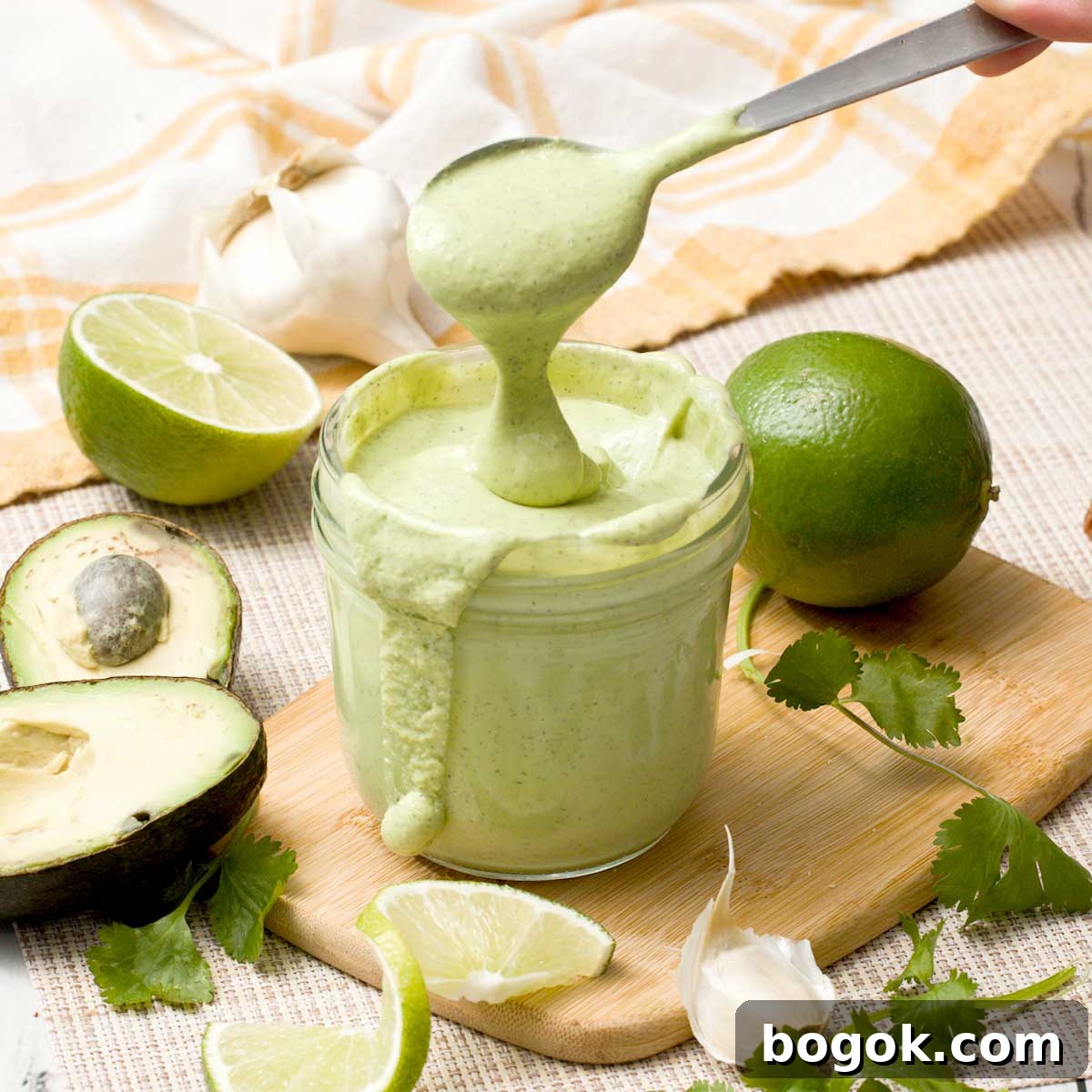 Garlic Parmesan White Bean Dip with Extra Protein 14 A spoon lifting avocado lime ranch dressing out of a mason jar.