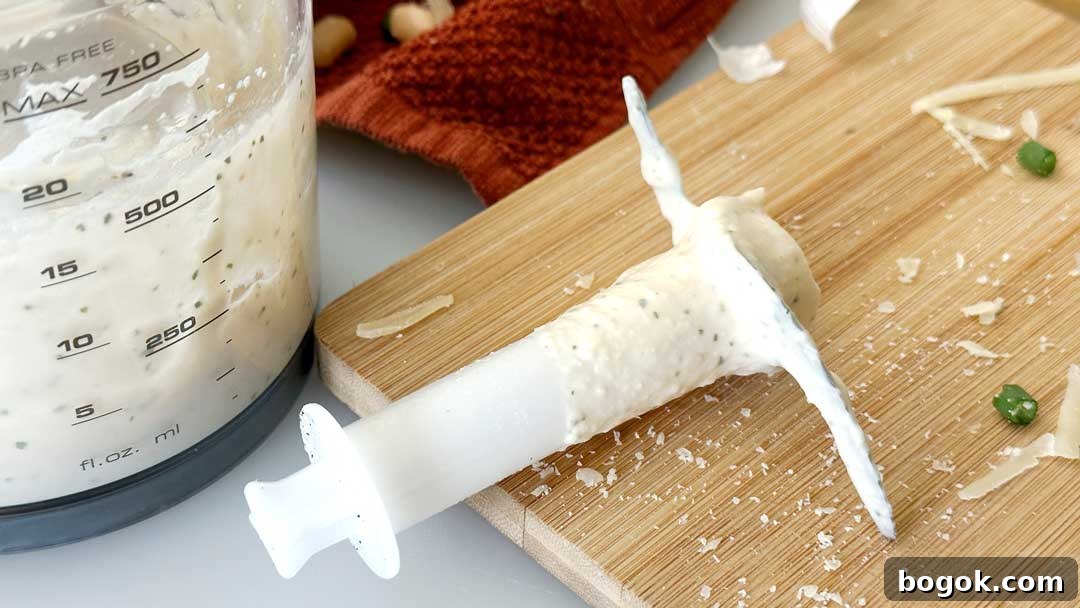 Garlic Parmesan White Bean Dip with Extra Protein 7 White blender blade with bean dip on it sitting on a cutting board.