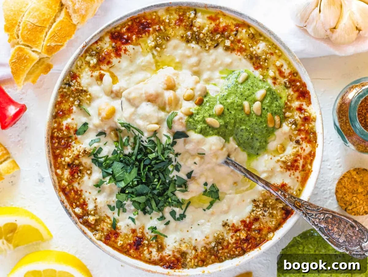 40 Delicious Chickpea Recipes for Every Meal and Occasion 14 Hummus masabacha with shatta sauce and a silver spoon