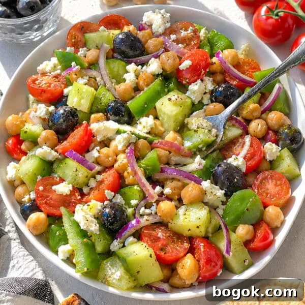 40 Delicious Chickpea Recipes for Every Meal and Occasion 30 Greek chickpea salad with a rustic silver fork.