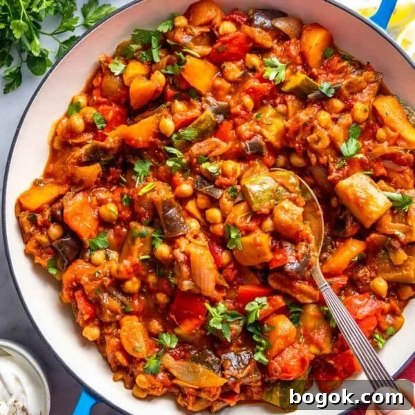 40 Delicious Chickpea Recipes for Every Meal and Occasion 31 Tagine in a blue skillet with a silver spoon.