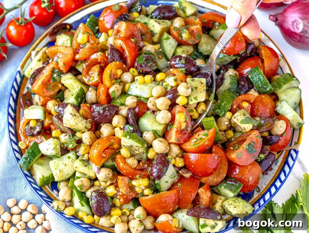 40 Delicious Chickpea Recipes for Every Meal and Occasion 6 Chickpea salad recipe with cherry tomatoes on the side and a hand