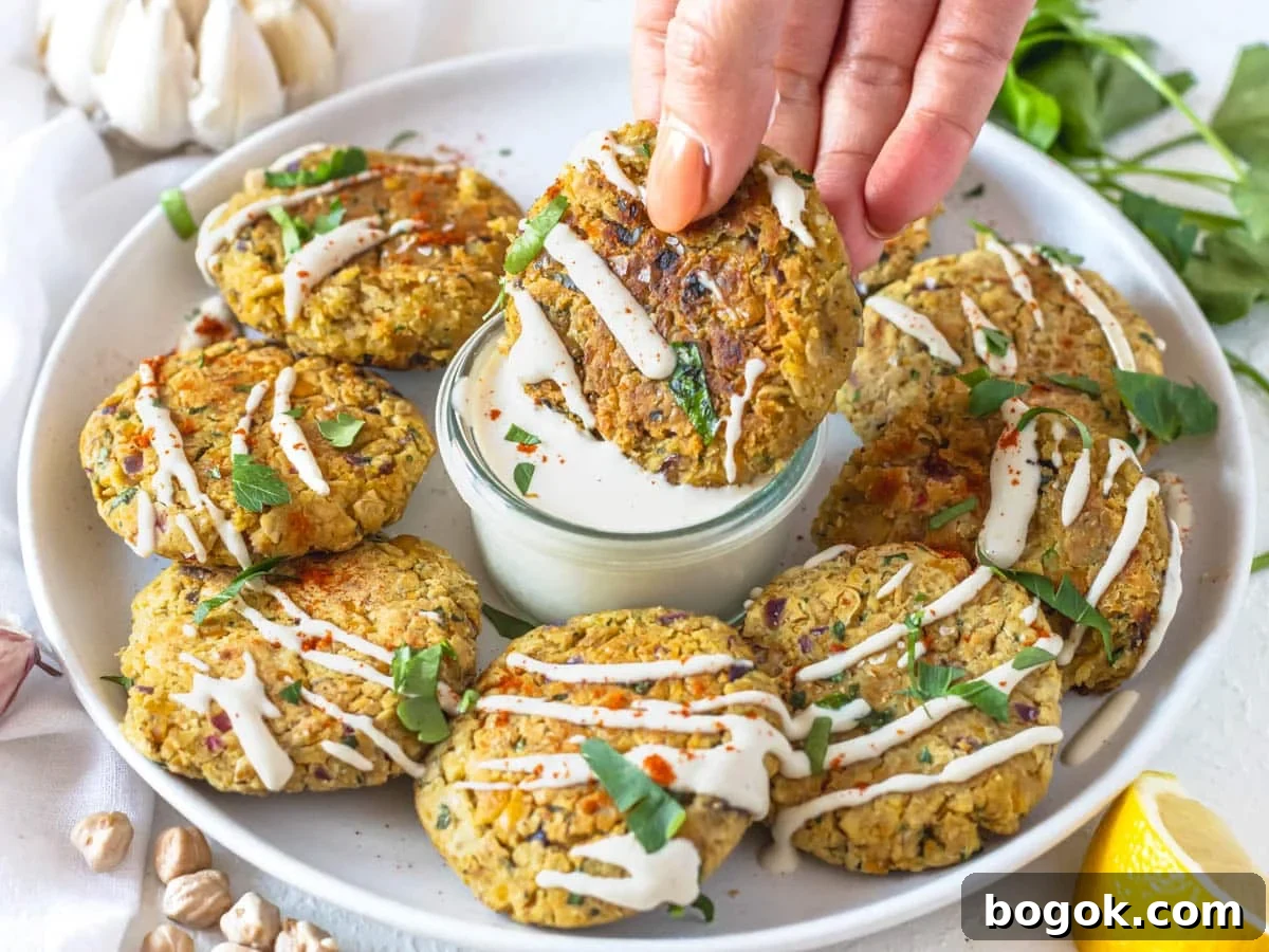 40 Delicious Chickpea Recipes for Every Meal and Occasion 10 Chickpea fritters with tahini sauce and fresh parsley and a hand dipping a fritter