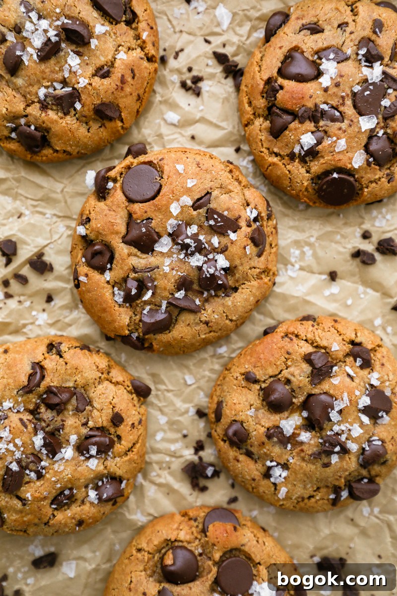 An up close shot of chocolate chips cookies stuffed with a sweet cream cheese filling and sprinkled with flakey sea salt