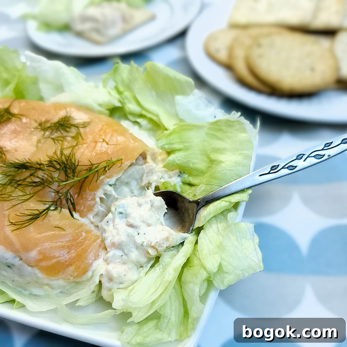 Easy salmon terrine on a plate. Some of the terrine is being spooned out.