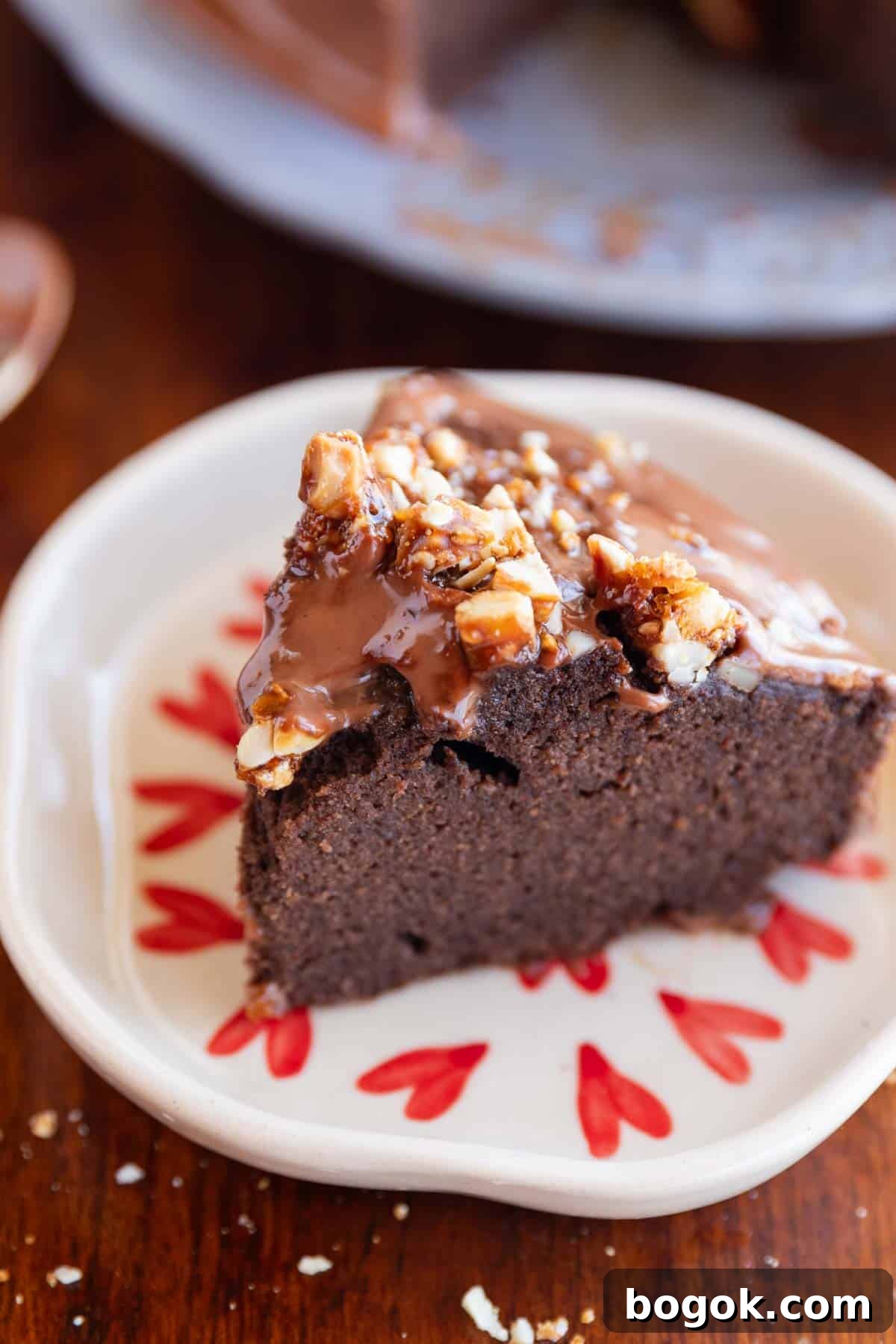 slice of ragi chocolate cake on a white plate with nuts sprinkled on top