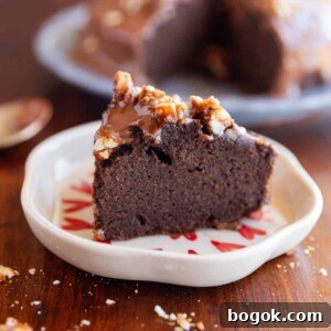slice of ragi chocolate cake on a white plate with nuts sprinkled on top