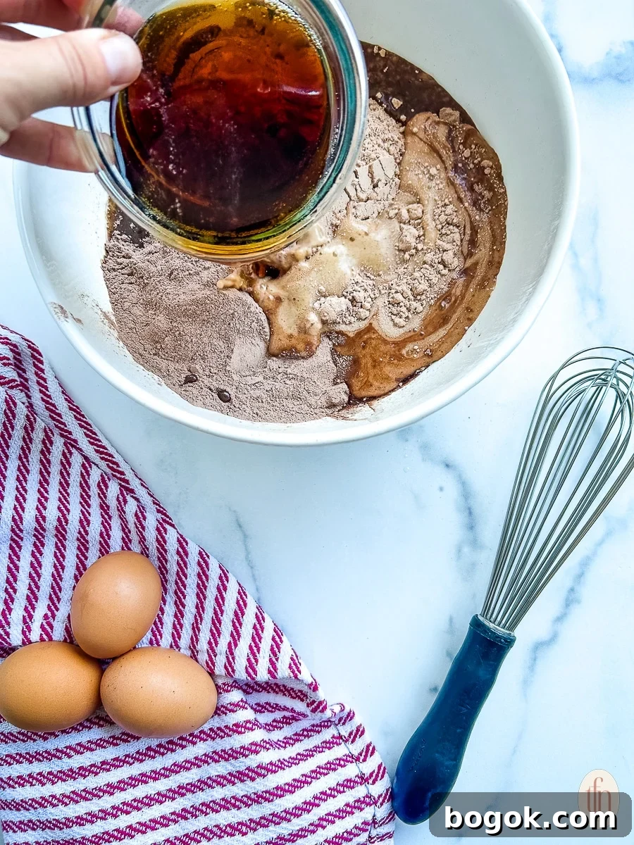Dr Pepper Chocolate Sheet Cake Recipe - Moist Soda Cake Tutorial 5 Pouring soda into white bowl with ingredients.