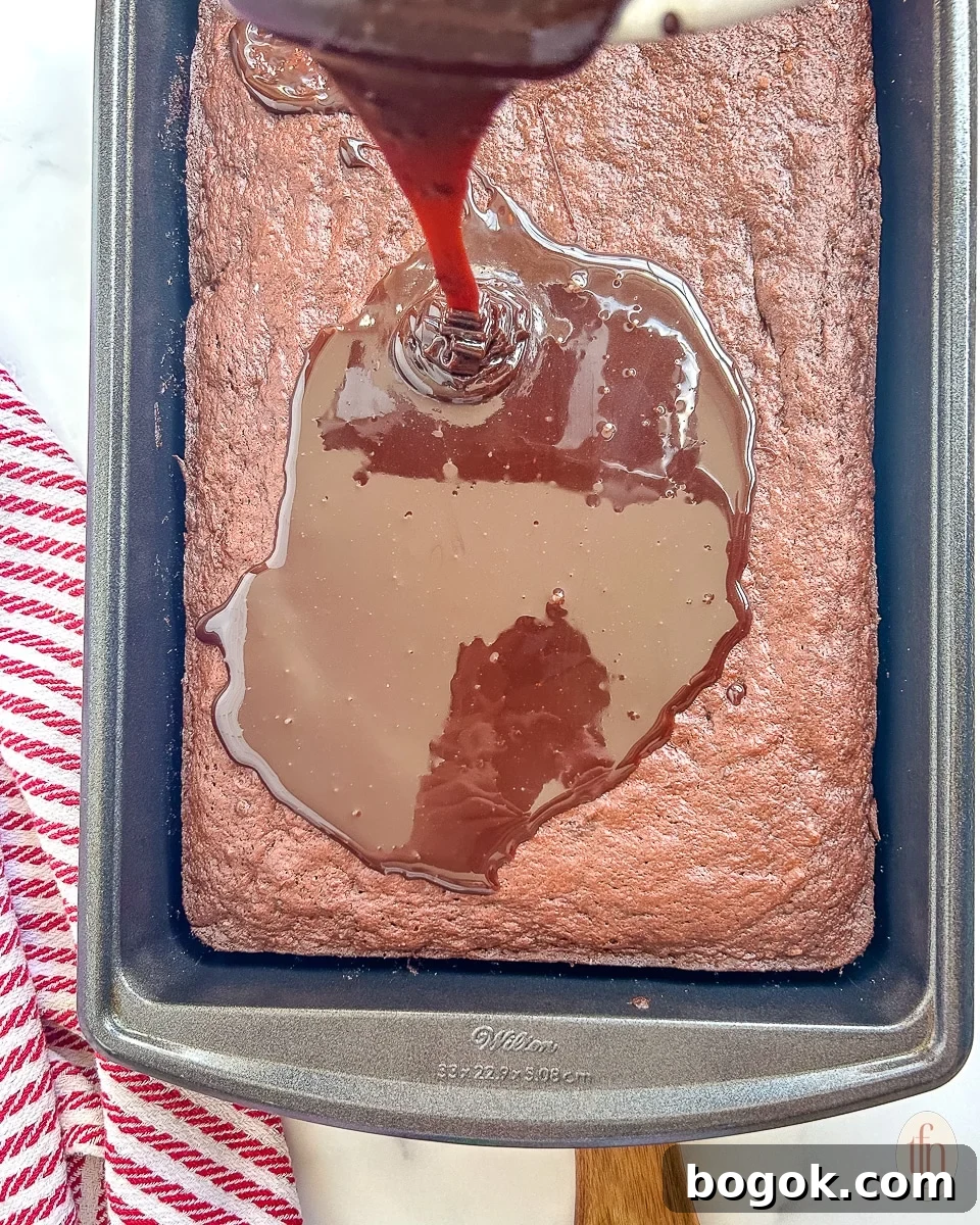 Dr Pepper Chocolate Sheet Cake Recipe - Moist Soda Cake Tutorial 7 Pouring chocolate fudge frosting over cake with Dr Pepper in the pan.