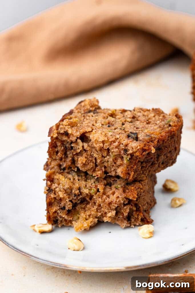 Ultra-Moist Gluten-Free Zucchini Bread with a Secret Ingredient 3 side view of slices of Extra Moist Gluten Free Zucchini Bread on a plate stacked on top of each other